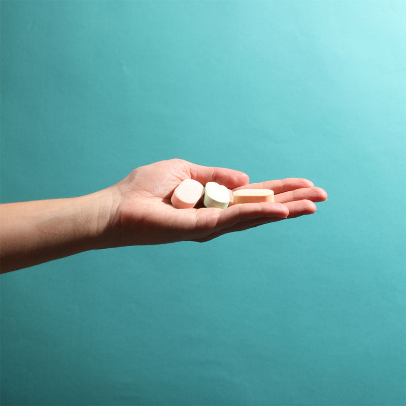 group of pill in different color in a teal background